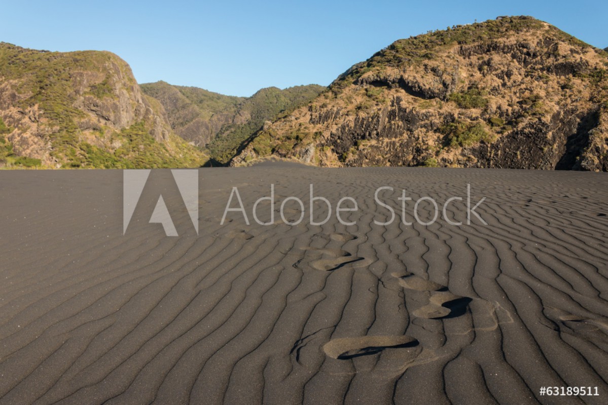 Afbeeldingen van Footprints accross black sand dune